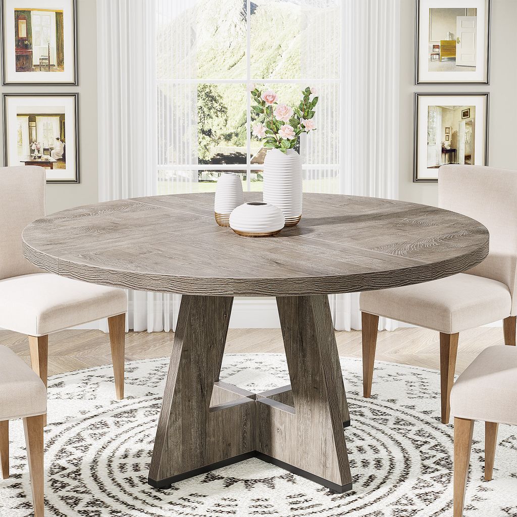 A round dining table with chairs in a dining room setting.