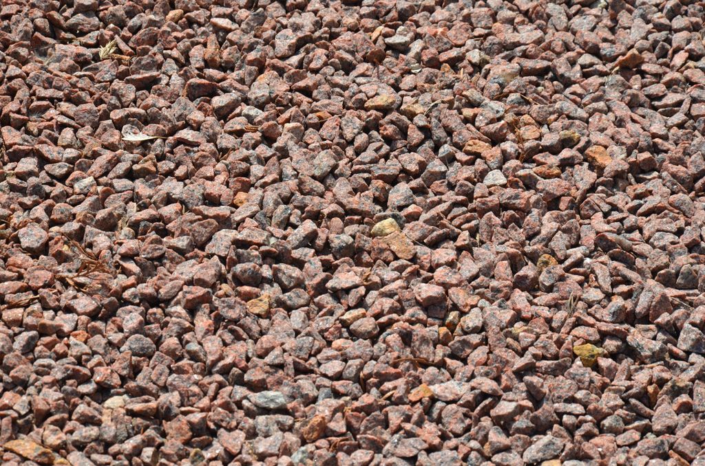 A close-up, overhead view of red granite gravel.