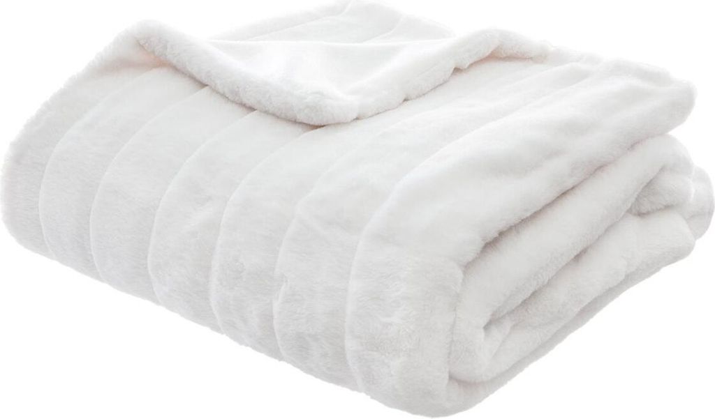 A folded white faux fur blanket.