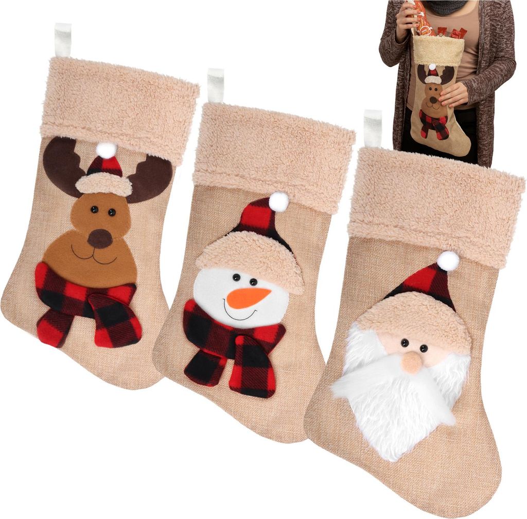 Three Christmas stockings with different designs (reindeer, snowman, Santa Claus) are displayed against a white background. A person is holding one of the stockings in the background.
