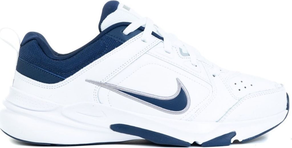 A side view of a white Nike shoe with navy blue accents.