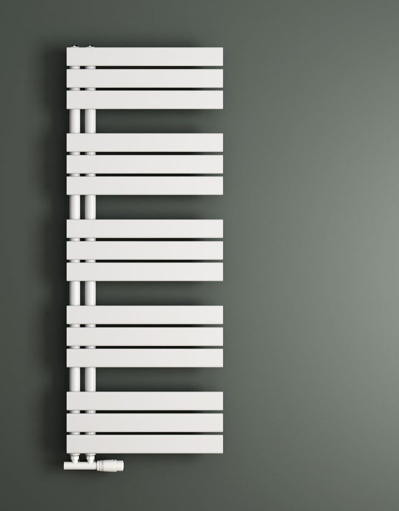 A white radiator is mounted on a gray wall.