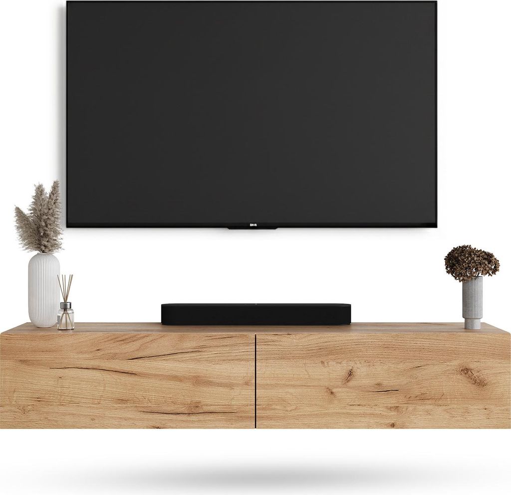 A TV stand with a TV mounted above it, and decorative items on the stand.