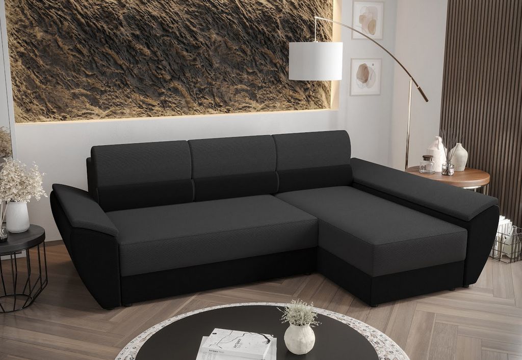 A dark gray and black sectional sofa is shown in a living room setting.