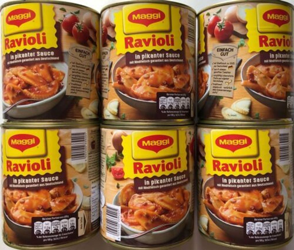A stack of four cans of Maggi Ravioli in pikanter Sauce.