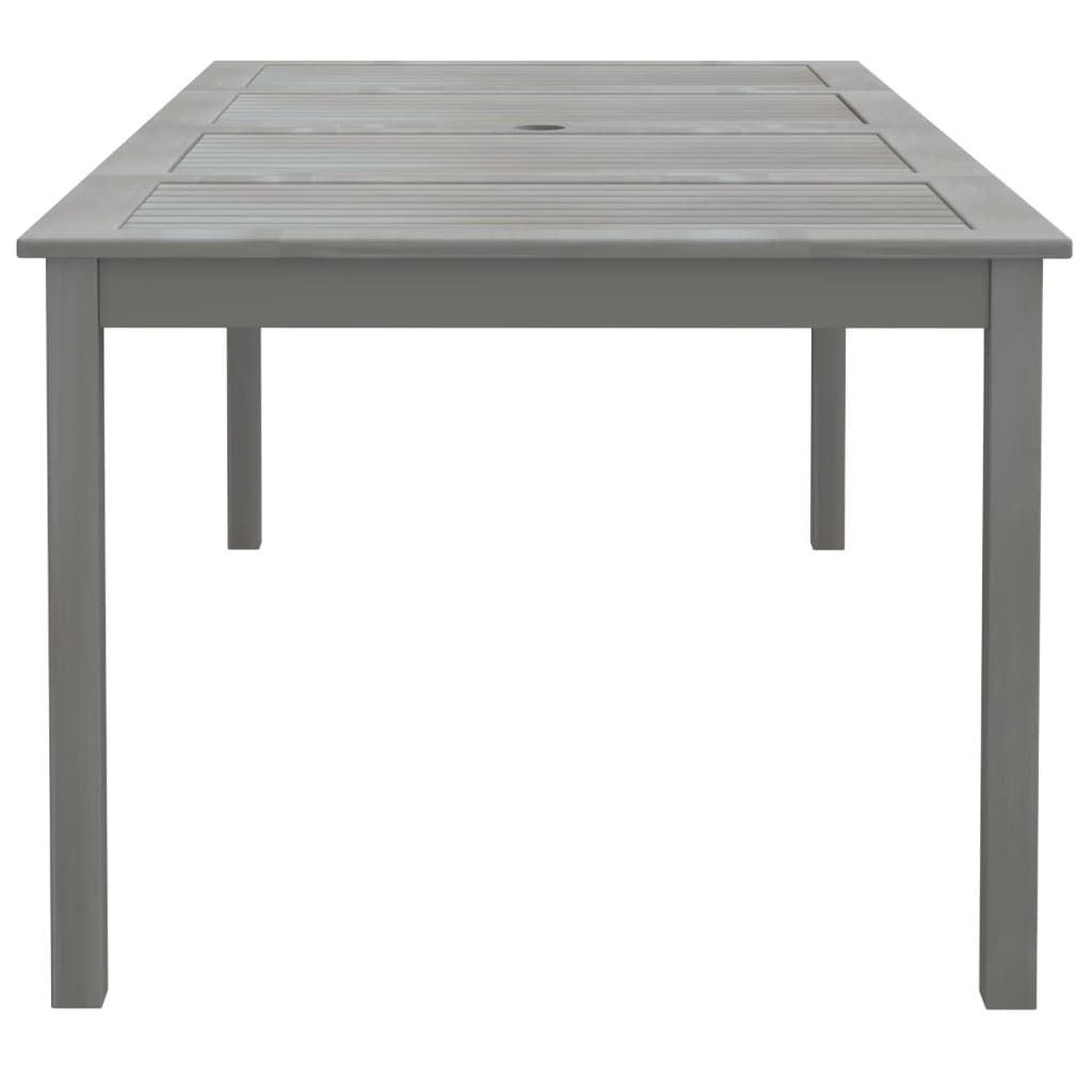 A gray wooden garden table with a slatted top and a hole for an umbrella.