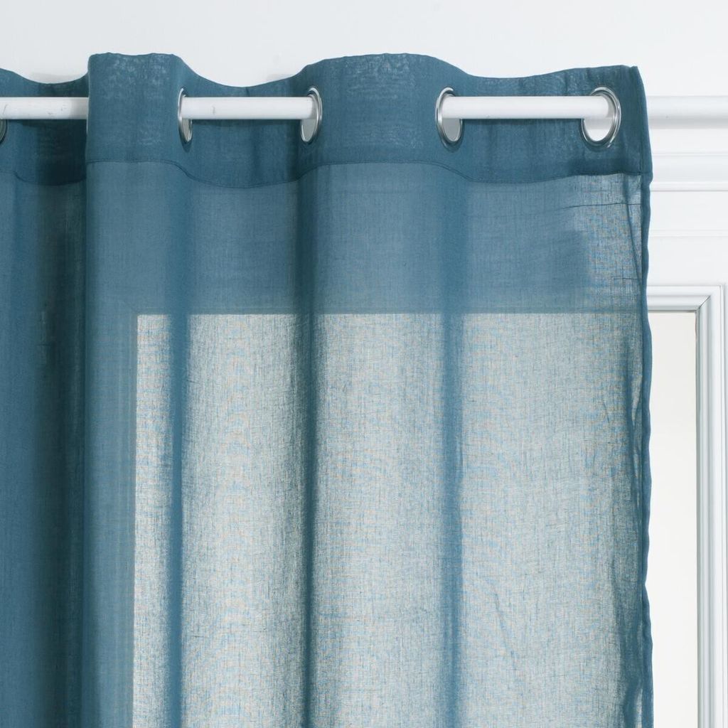 A close-up view of a blue curtain hanging from a white curtain rod.