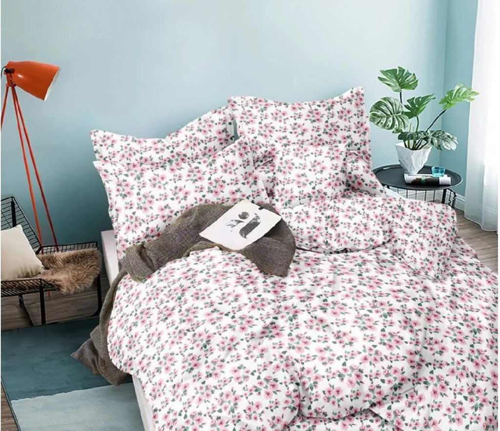 A bedroom scene with a bed dressed in floral bedding.