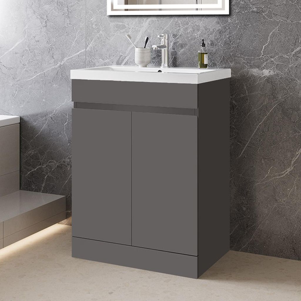 A modern bathroom vanity with a sink and faucet, set against a marble-patterned wall.