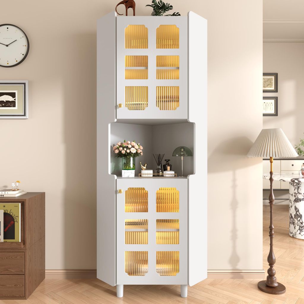 A white corner cabinet with glass doors and gold accents, decorated with flowers and other items, is shown in a room with a clock and a floor lamp.