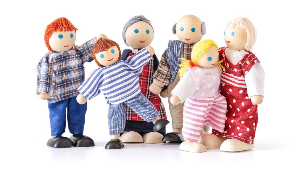 A group of wooden dolls representing a family, posed against a white background.