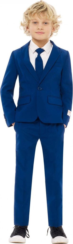 A young boy is standing and posing in a blue suit.