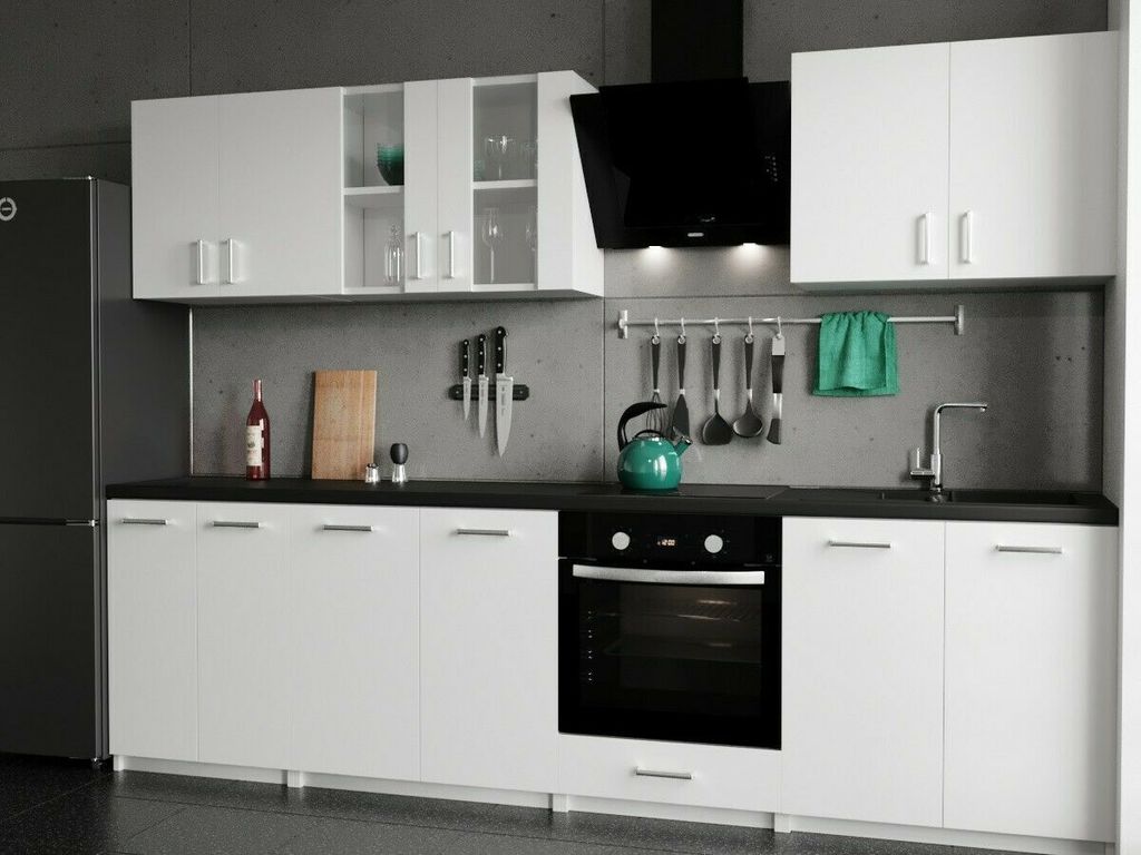 A modern, white kitchen setup with cabinets, an oven, and a refrigerator.