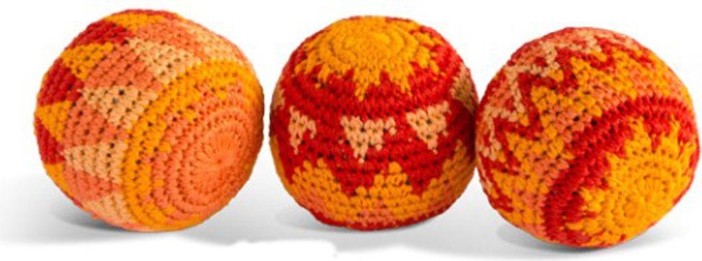 Three crocheted balls arranged in a row on a white and gray background.