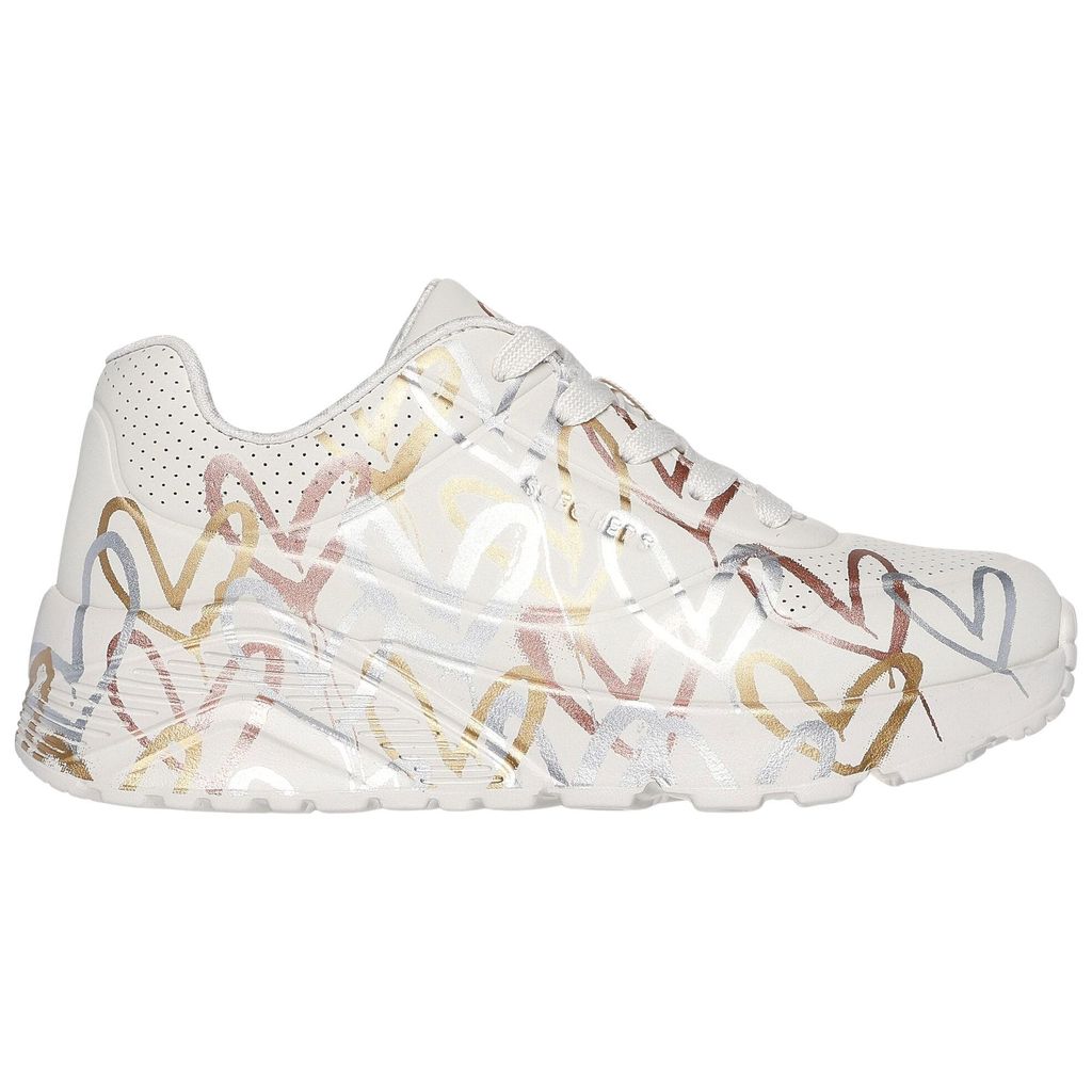 A side view of a white sneaker with a heart pattern.