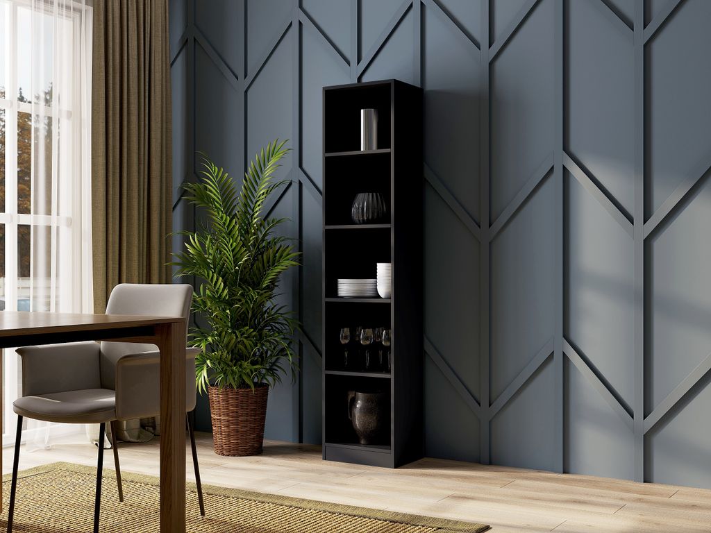 A tall, black bookshelf filled with decorative items and glassware, placed in a room with a textured blue wall and a dining table with chairs.