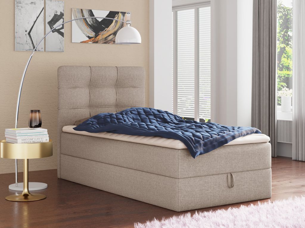 A bedroom scene with a bed, side table, and lamp.