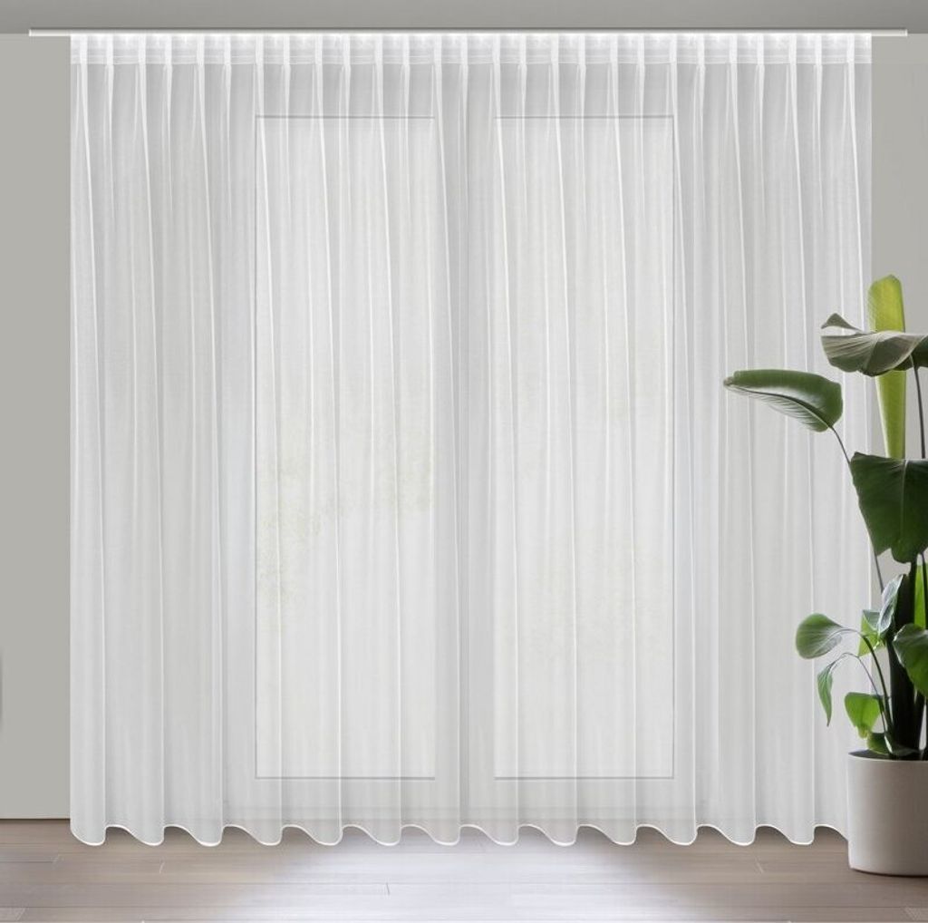 A white sheer curtain is hung in front of a window.