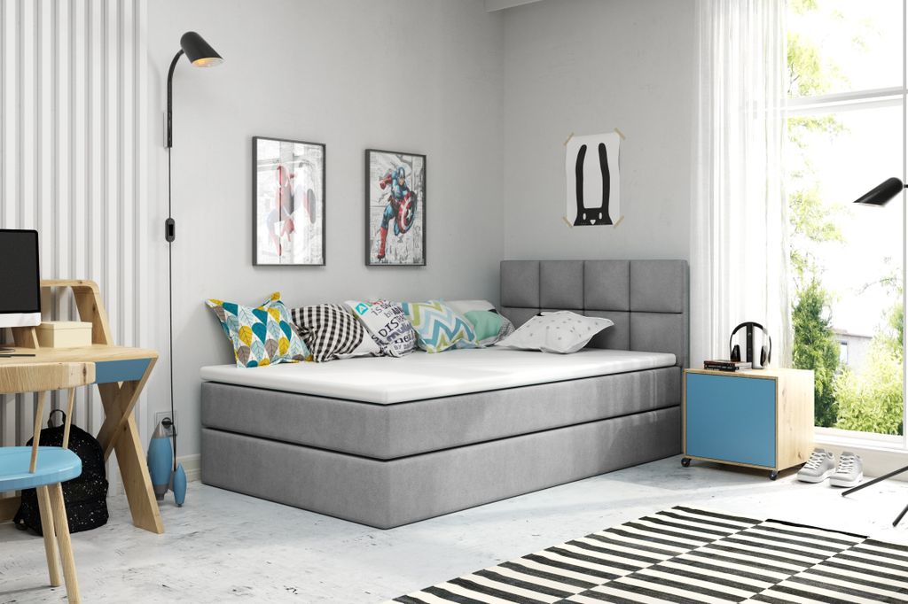 A bedroom with a bed, desk, and lamp.
