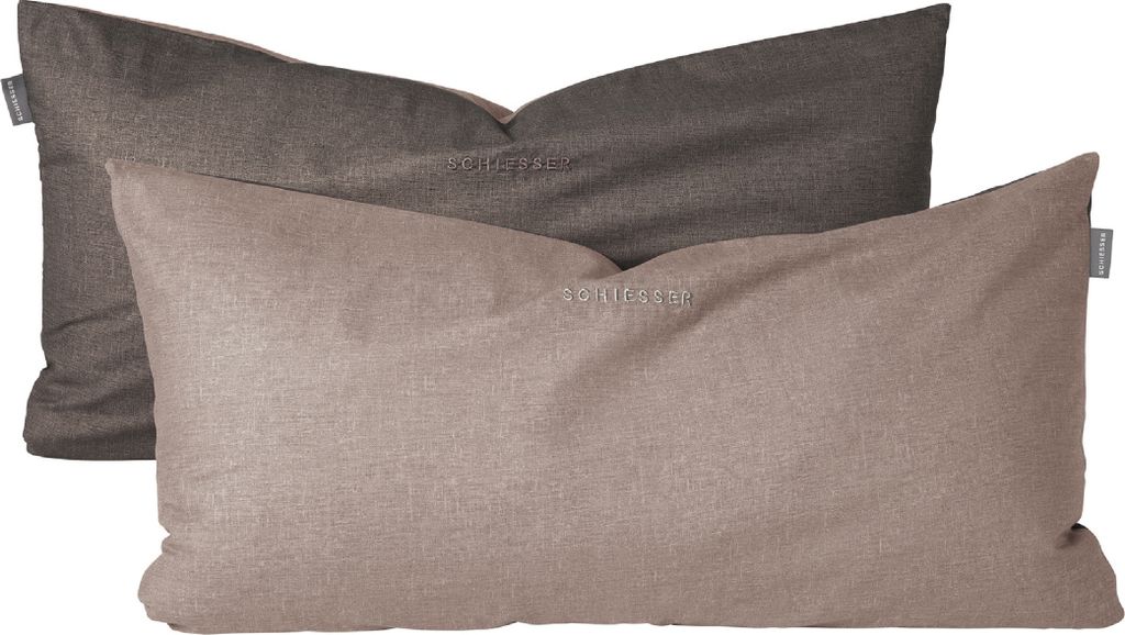 Two pillows are stacked on top of each other, with the lighter colored pillow in front.