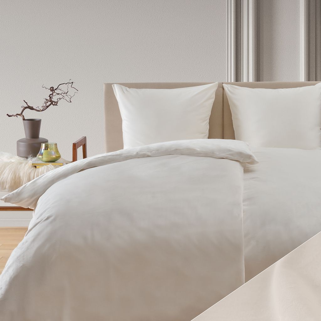 A neatly made bed with white bedding and pillows.