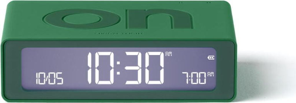 A green digital alarm clock with a digital display showing the time and alarm settings.