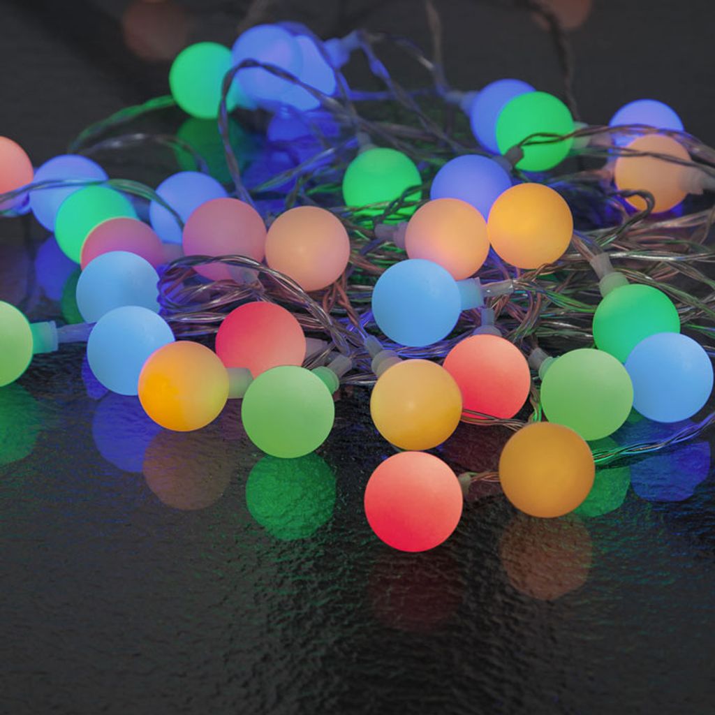 A pile of colorful LED party lights on a dark surface.