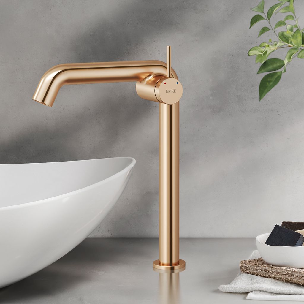 A rose gold faucet is shown next to a white sink in a bathroom setting.