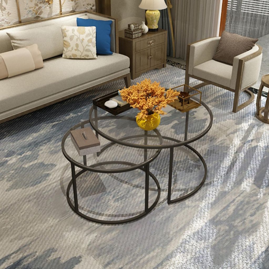 A living room scene with a couch, armchair, and nesting coffee tables.