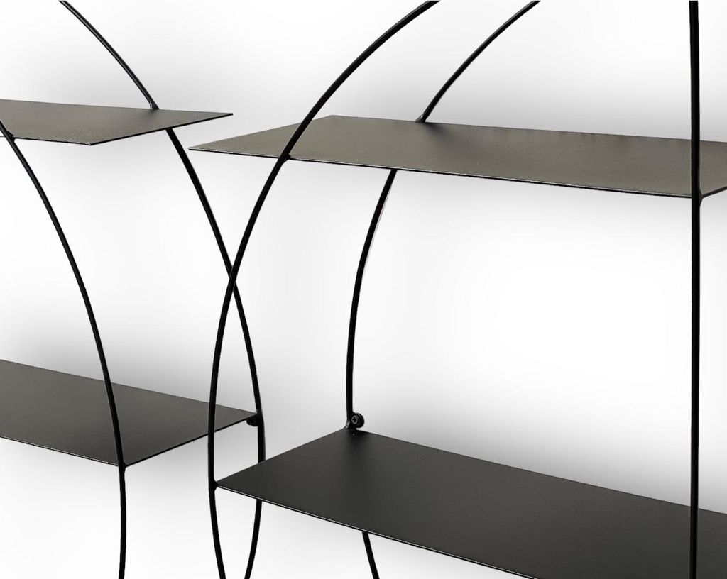 A close-up view of a black metal wall shelf unit against a white background.