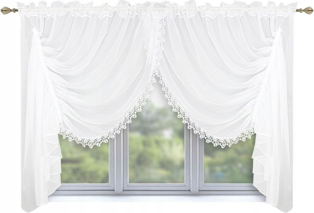 A white lace curtain is draped over a window with a blurred green background of trees.