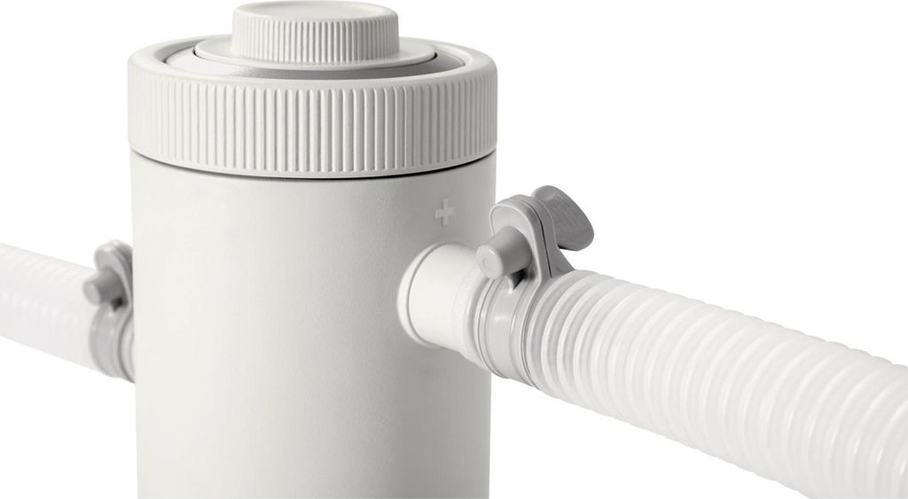 A close-up shot of a white pool filter pump with a white hose attached.
