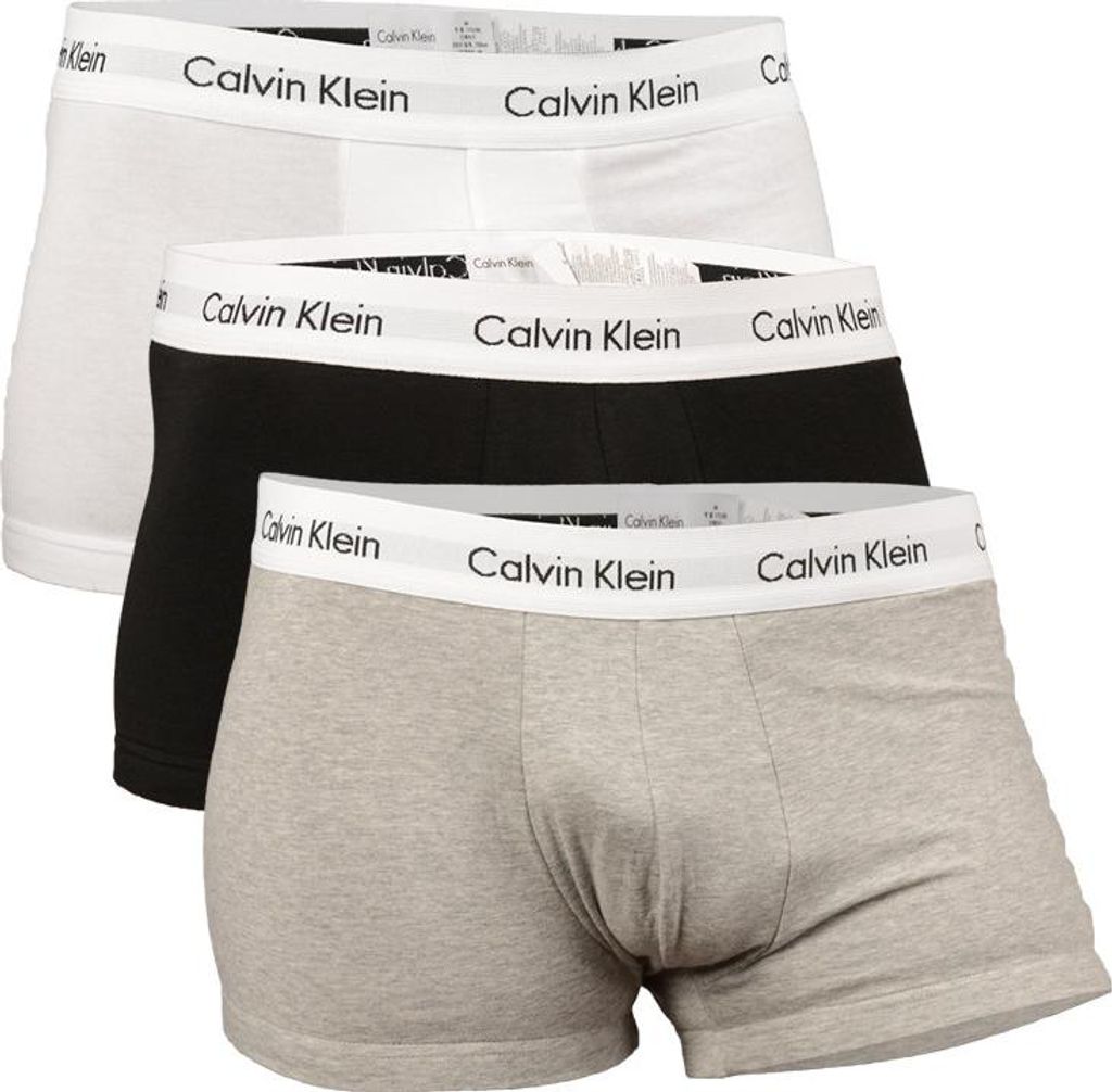 A stack of three Calvin Klein boxer shorts in different colors.