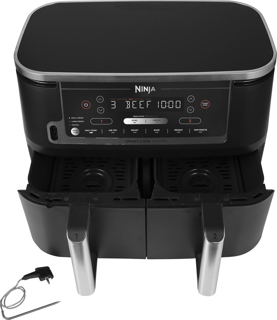 A black Ninja Foodi Max Dual Zone air fryer with its control panel and dual baskets visible, placed on a white background. A thermometer probe accessory is also shown.