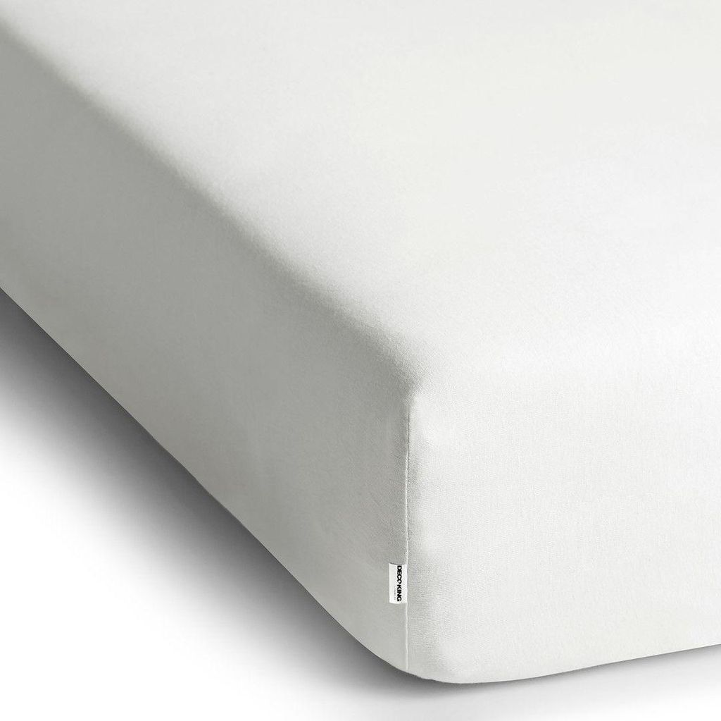 A close-up, angled view of a white fitted sheet.