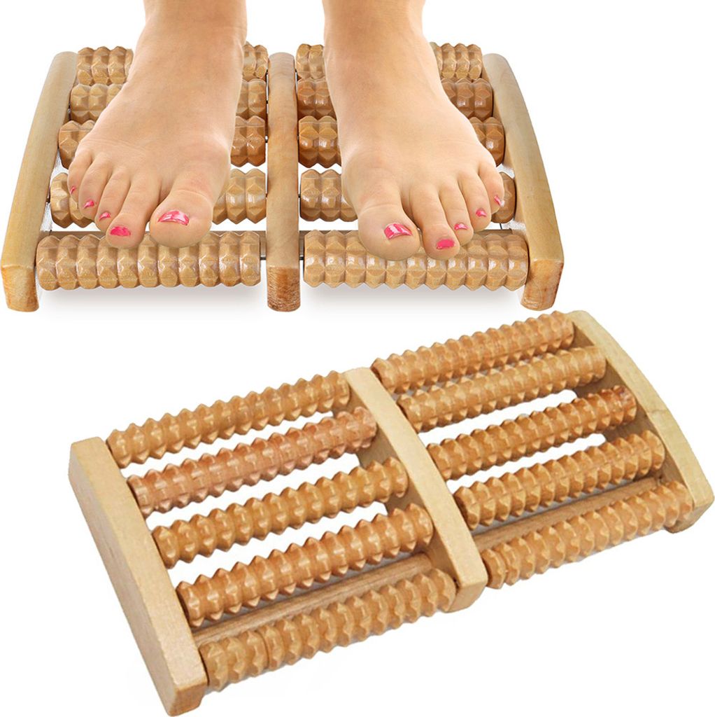A pair of feet resting on a wooden foot massager.