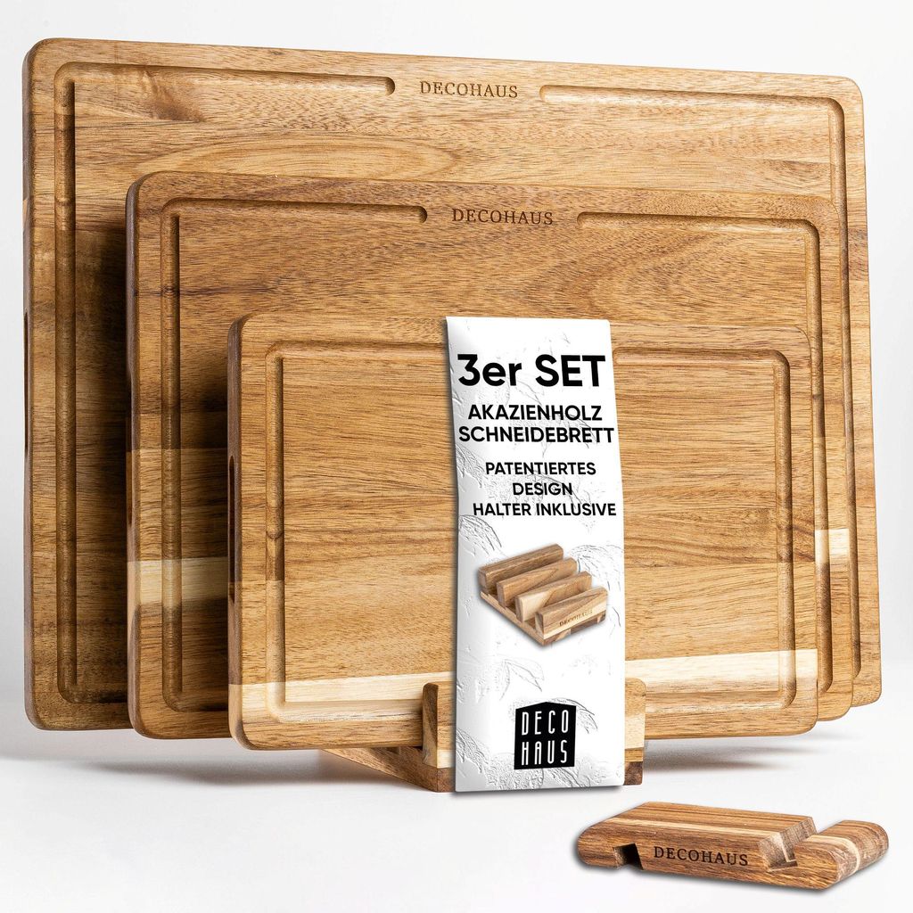 A set of three wooden cutting boards of different sizes, stacked and displayed with a product information card and a small wooden holder.