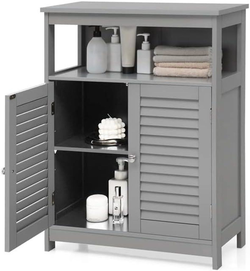 A gray bathroom storage cabinet with its left door open, displaying shelves and items like bottles, a candle, and towels.
