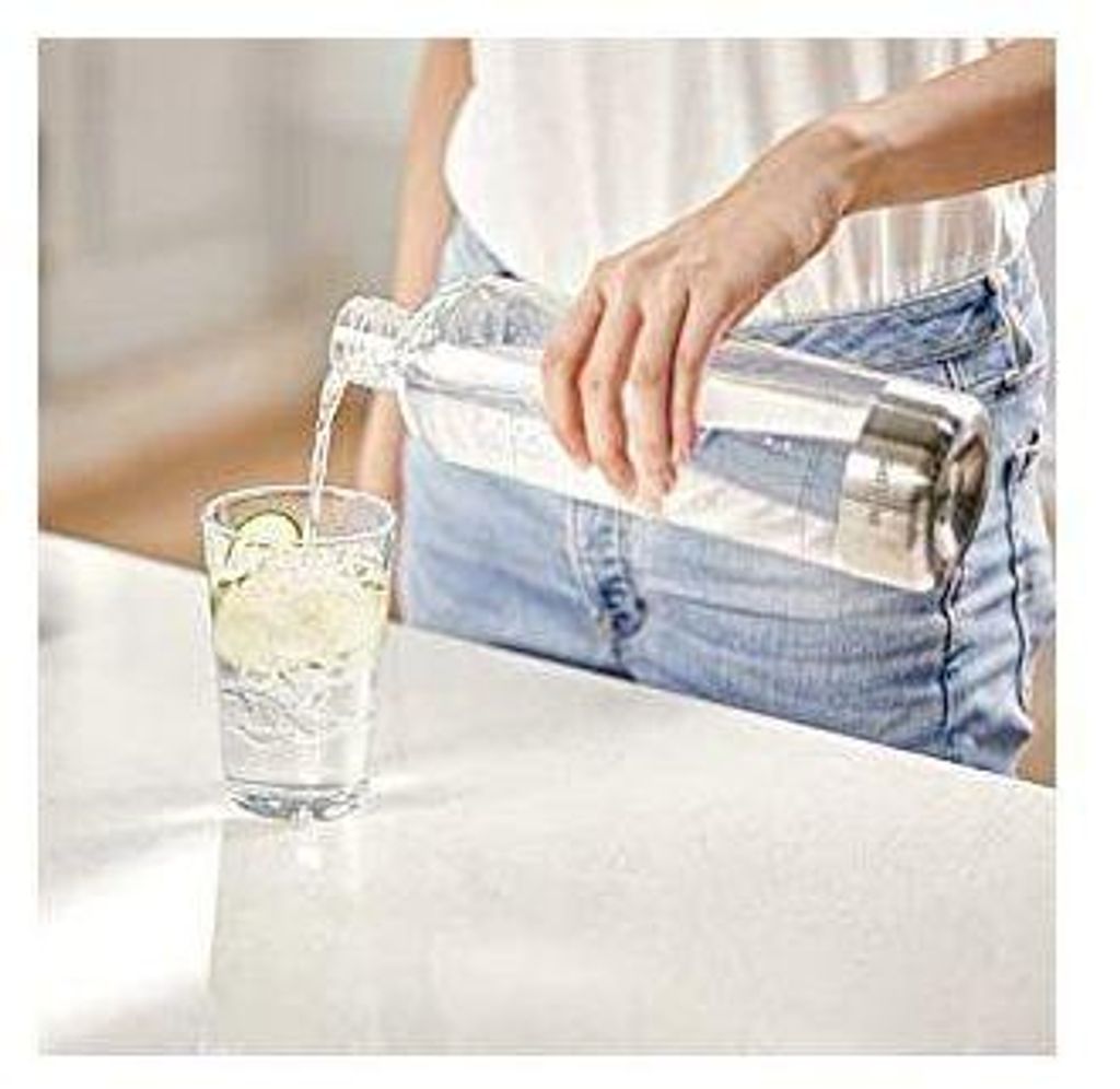 A person is pouring water from a bottle into a glass.