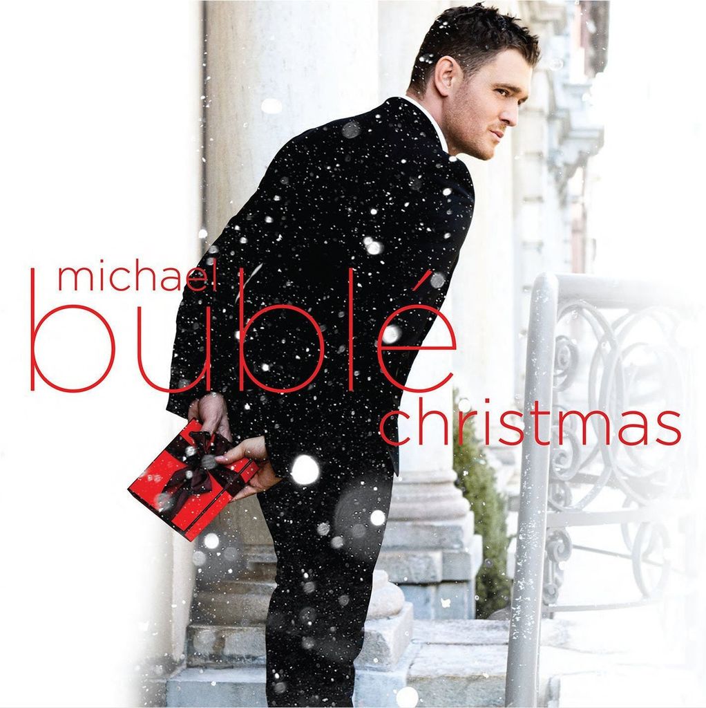 Michael Buble holding a Christmas gift while snow falls.