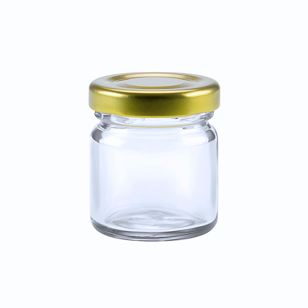 A clear, studio shot of a small, empty glass jar with a gold metal twist-off lid, isolated on a white background.