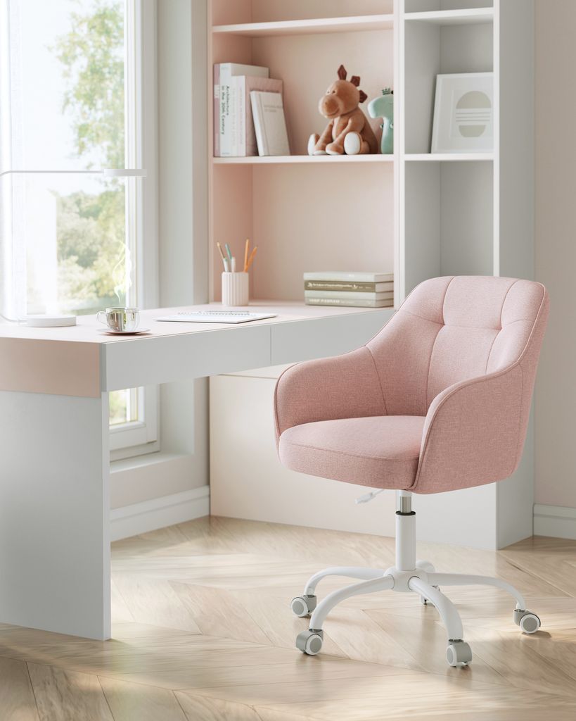 A pink office chair next to a white desk with a bookshelf in the background.