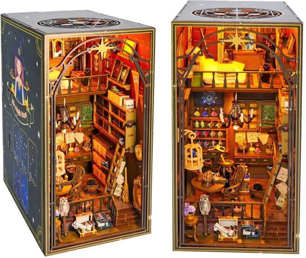 A diorama of a magical library or study, with shelves, furniture, and decorative items, illuminated by LED lights.