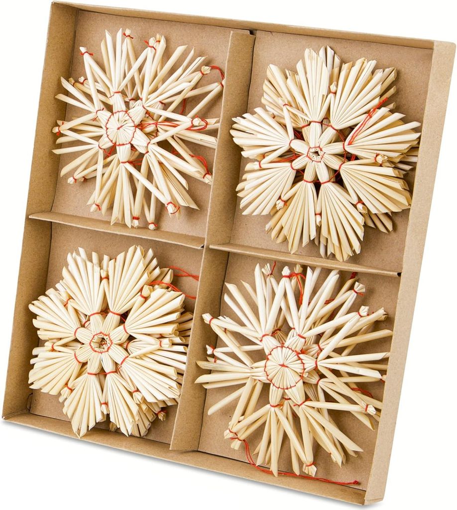 A set of four straw star ornaments in a cardboard box.