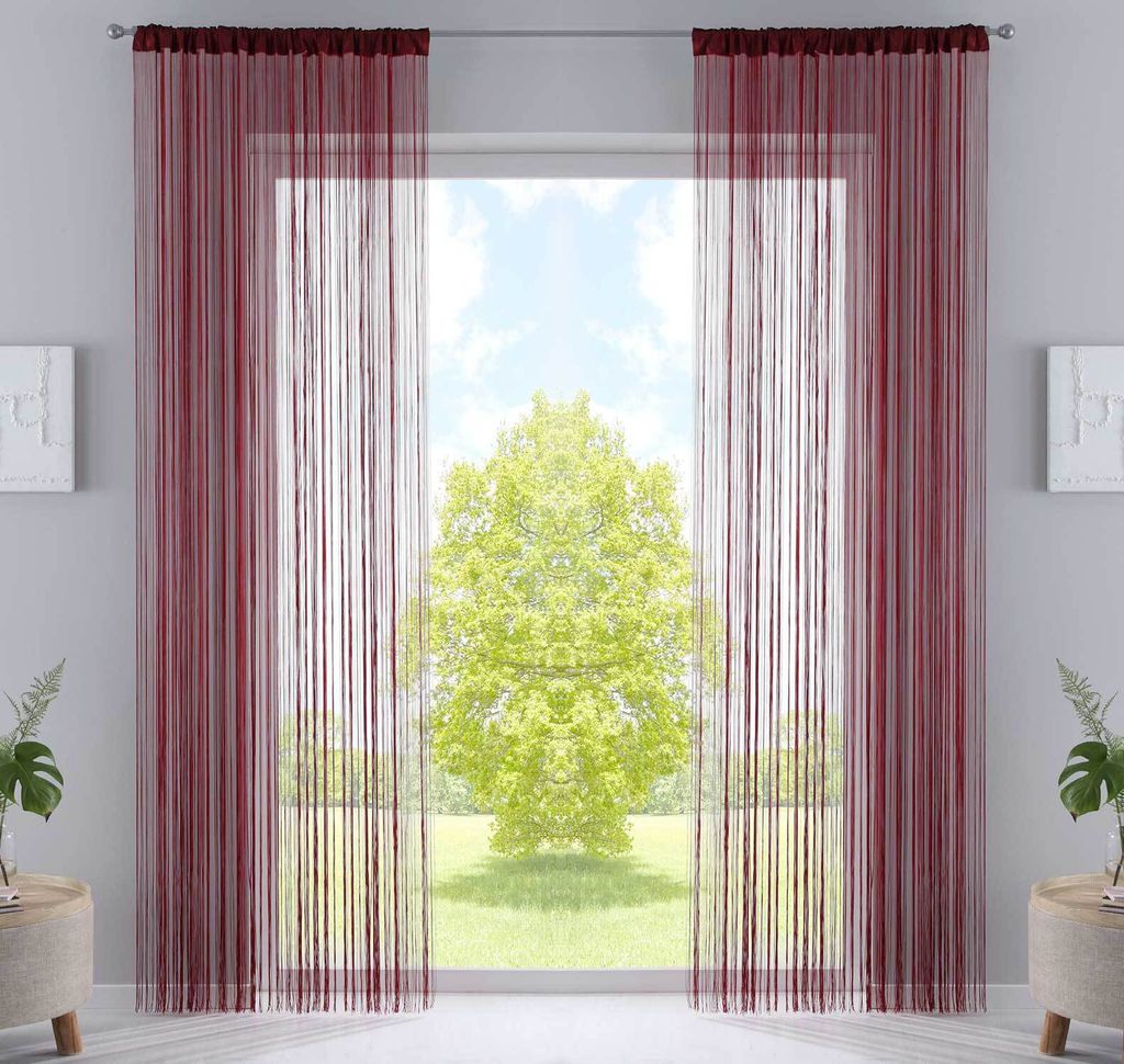 A window with burgundy string curtains and a view of a green tree outside.
