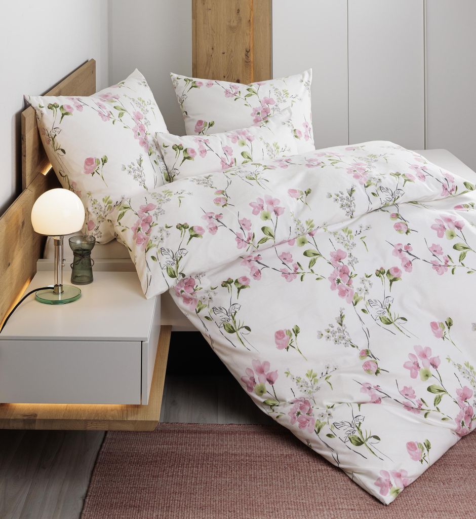 A close-up view of a bed with floral patterned bedding.