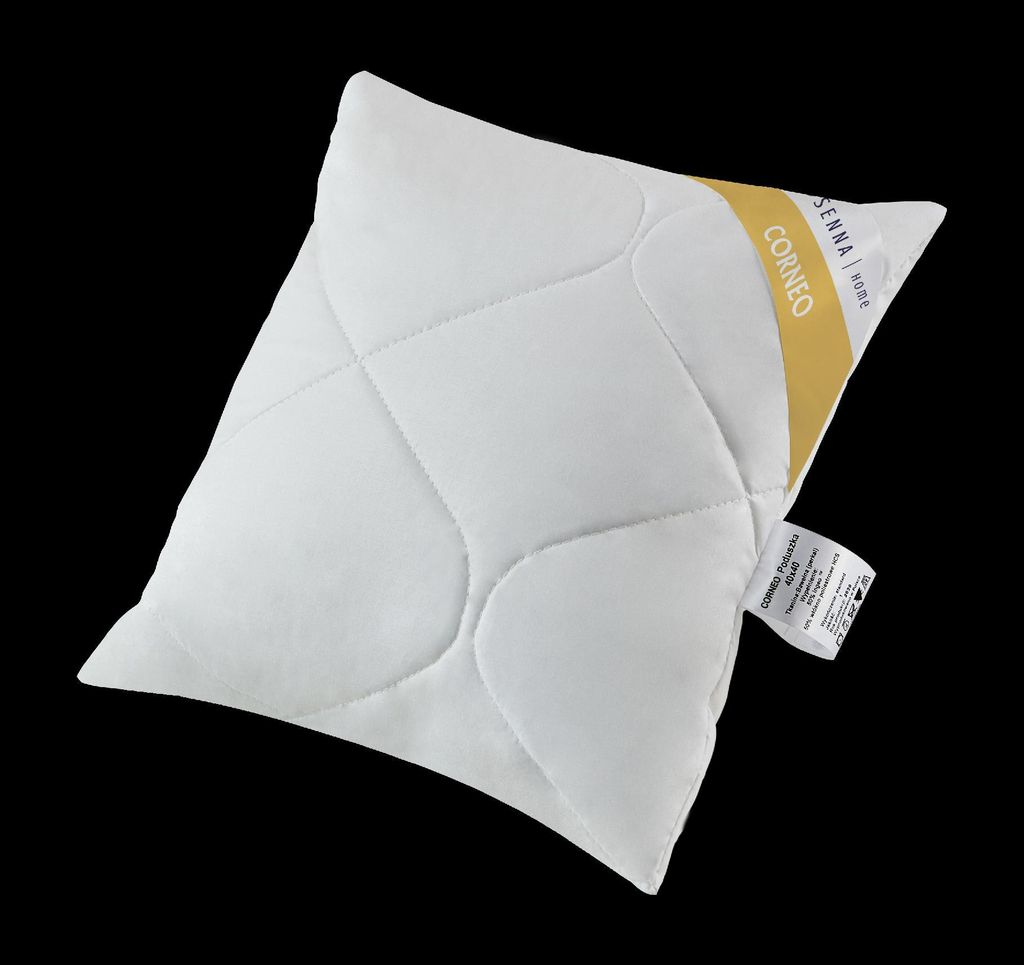 A white pillow with a yellow and white tag on it, set against a black background.