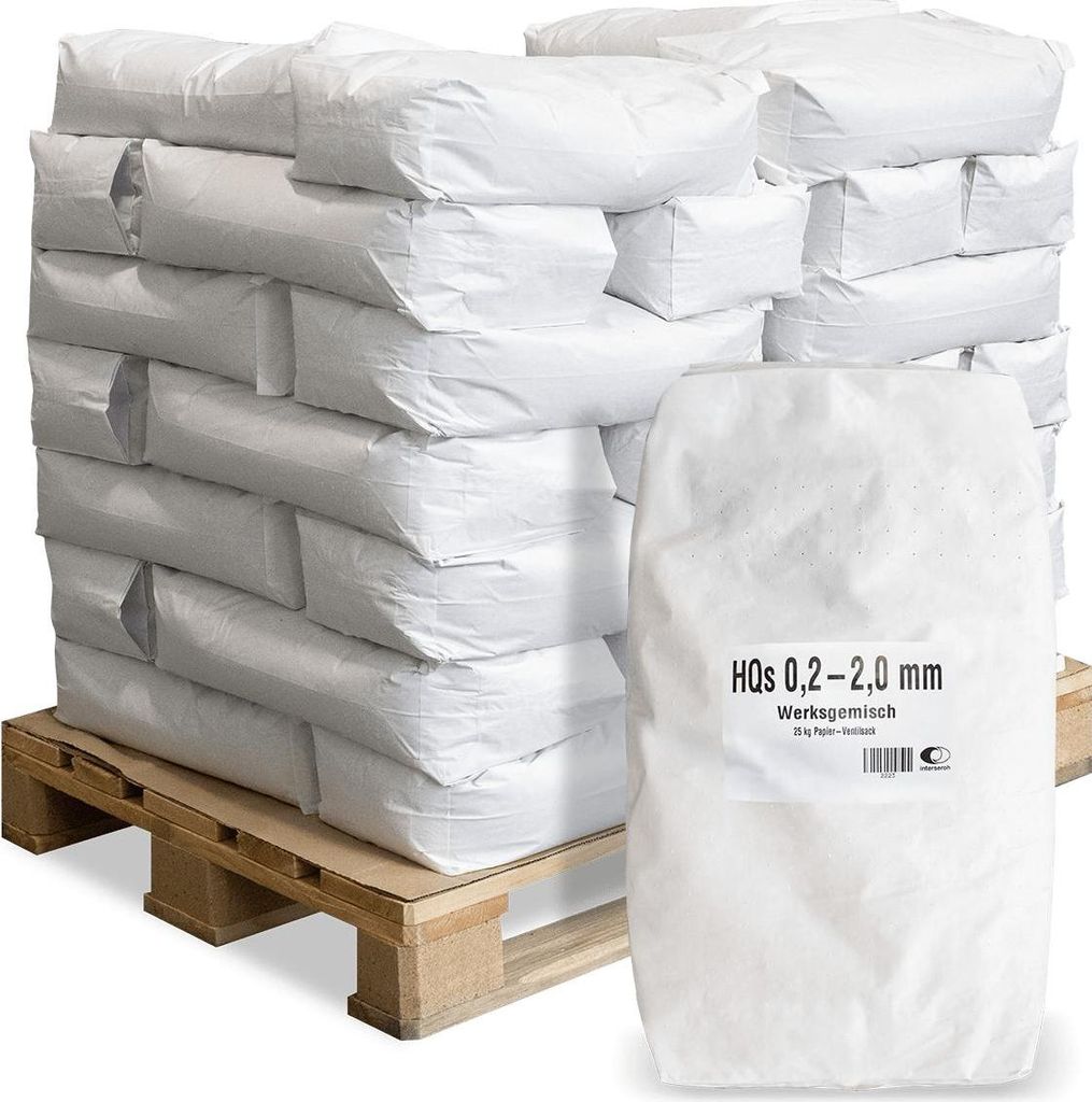 A stack of white bags on a wooden pallet, with one bag in the foreground showing a label.