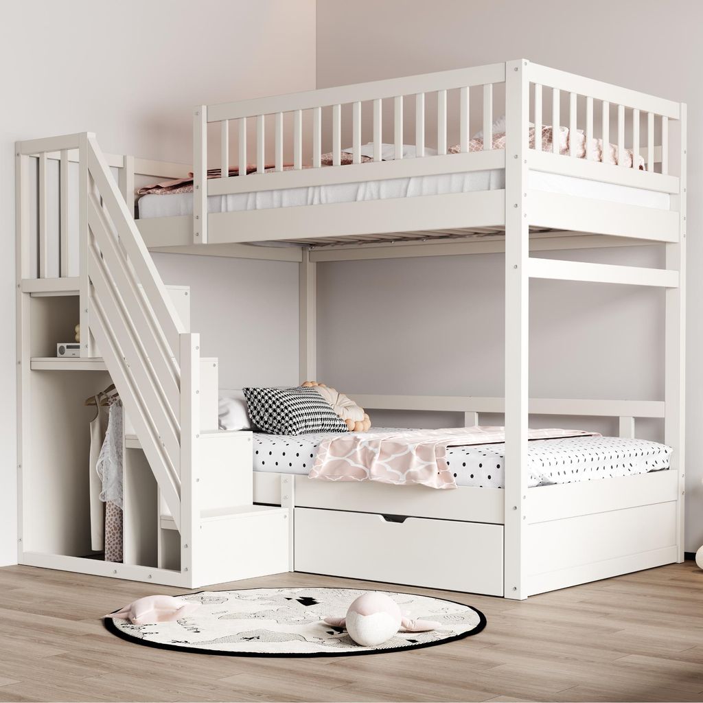 A white bunk bed with stairs and storage drawers in a room.