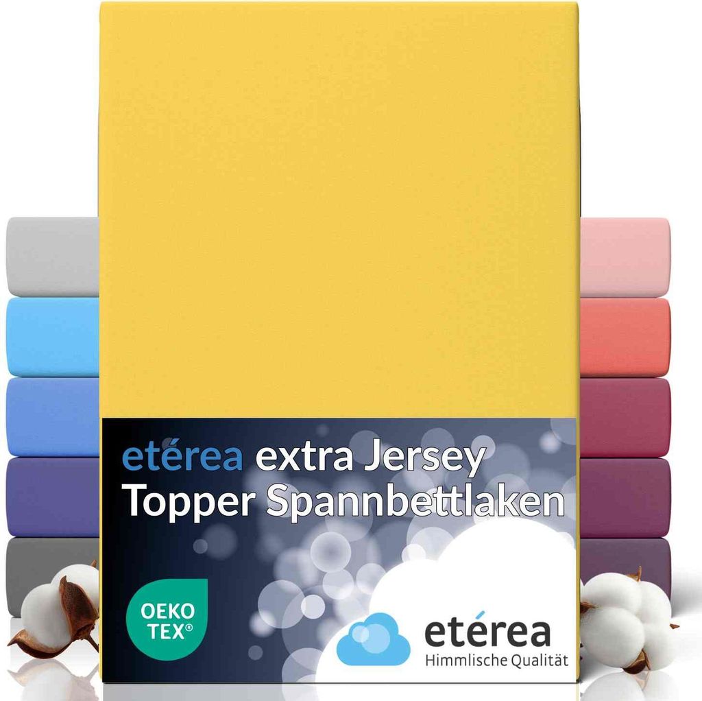 A stack of folded bed sheets in various colors, with a yellow sheet prominently displayed at the front.